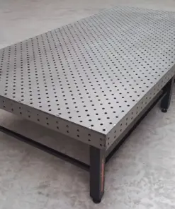 Grote industriële lastafel met gatenpatroon en opspansysteem voor nauwkeurig laswerk en staalconstructies in een professionele metaalwerkplaats.